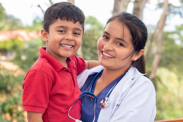 Portret szczęśliwego dziecka trzymanego przez pediatrę. Portret uśmiechniętego lekarza i dziecka