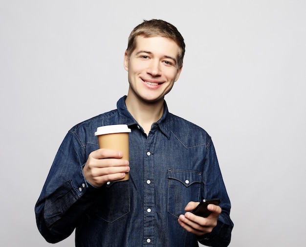 Portret szczęśliwego mężczyzny rozmawiającego przez telefon i pijącego kawę