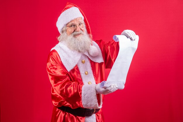 Portret szczęśliwego Mikołaja czytanie listu Bożego Narodzenia lub listy życzeń.