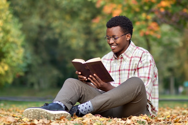 Portret szczęśliwego pozytywnego czarnego afrykańskiego człowieka afro amerykański etniczny inteligentny młody czytelnik czytelnik w
