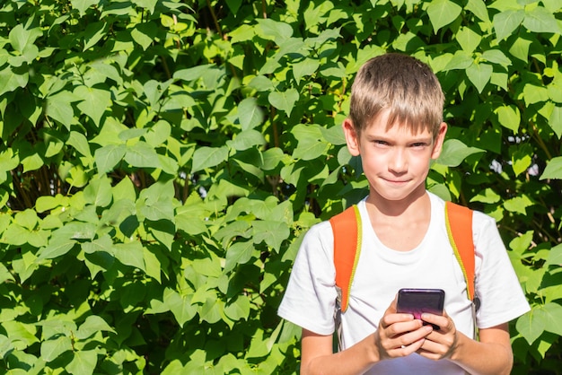 Portret Szczęśliwego Ucznia Z Plecakiem Za Pomocą Smartfona Piszącego Wiadomości Online Na Ulicy