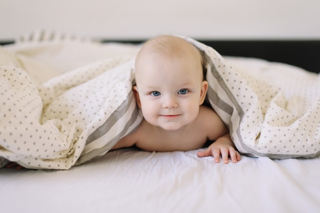 Portret szczęśliwego zdrowego dziecka w łóżku.