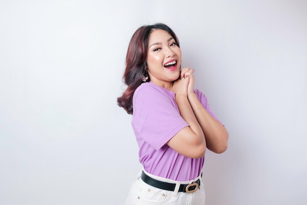 Portret szczęśliwej Azjatki w liliowo-fioletowej koszulce odizolowanej na białym tle