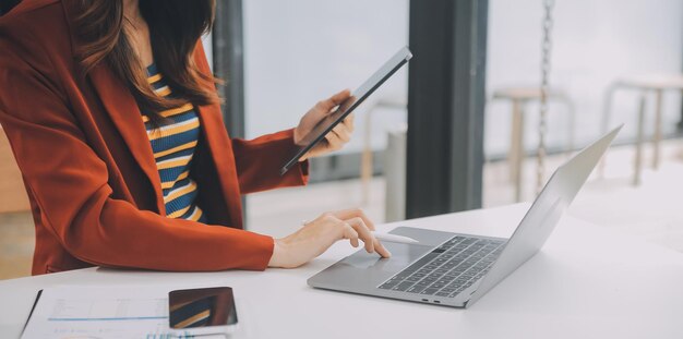 Portret szczęśliwej azjatyckiej bizneswoman korzystającej z telefonu komórkowego w pomieszczeniach azjatycka bizneswoman pracująca w nowoczesnym biurze