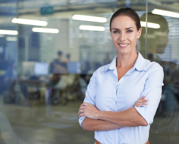 Portret szczęśliwej bizneswoman z skrzyżowanymi ramionami makietę i pewność siebie w pracy w agencji cyfrowej Doradca profesjonalna kobieta w tech startup lub kierownik projektu w przestrzeni biurowej z uśmiechem na twarzy