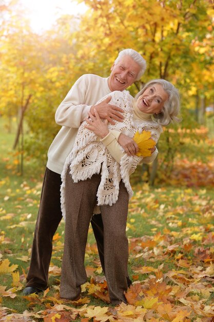 Portret szczęśliwej dojrzałej pary pozującej się na zewnątrz w jesiennym parku