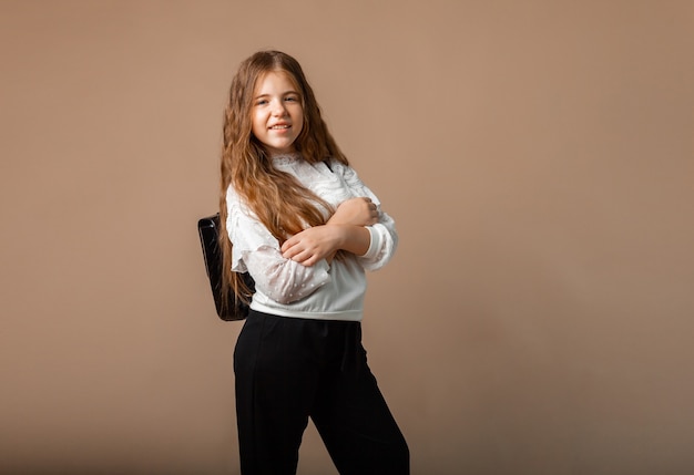 Portret szczęśliwej dziewczynki 12 lat stojącej i pozującej na tle studio