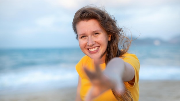 Portret szczęśliwej dziewczyny, młodej beztroskiej kobiety, która cieszy się wakacjami na morzu, spacerując po piasku na plaży, uśmiechając się i bawiąc się w tropikalnym kraju, relaksując się na łonie natury Koncepcja szczęścia w lecie