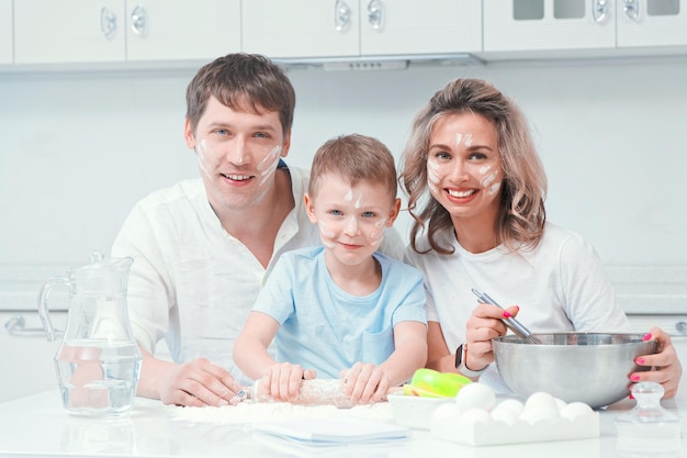 Portret szczęśliwej młodej rodziny z małym synkiem w kuchni