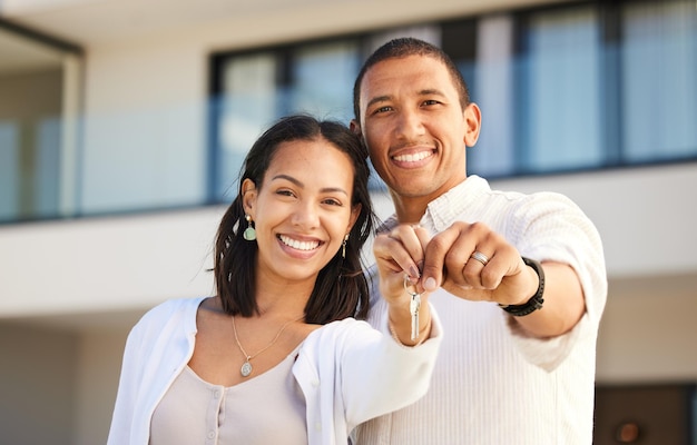 Portret szczęśliwej pary i trzymając klucze do domu z uśmiechem do celów związanych z relacjami i małżeństwem Podekscytowani właściciele domów mężczyzna i kobieta uśmiechają się z kluczem wprowadzającym się do nieruchomości i nowego domu