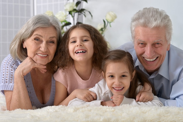 Portret szczęśliwej pary seniorów z wnukami w domu