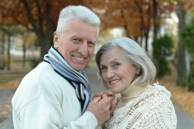Portret szczęśliwej pary starszych w jesiennym parku