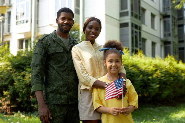 Portret szczęśliwej rodziny Afroamerykanów z tatą wojskowym uśmiechającym się do kamery podczas Dnia Niepodległości