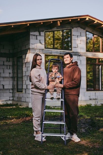 Zdjęcie portret szczęśliwej rodziny mama tata i syn bawiący się i cieszący się razem w jesienny słoneczny dzień rodzice budują dom marzeń hipoteczny