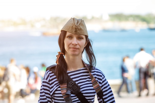 Zdjęcie portret szczęśliwej słodkiej kobiety w kamizelce i czapce wojskowej na głowie