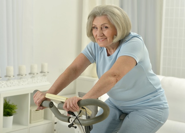 Portret szczęśliwej starszej kobiety ćwiczącej na rowerze