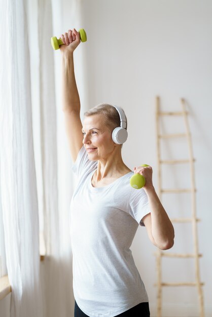 Portret Szczęśliwej Starszej Kobiety Robi ćwiczenia Fitness Z Hantlami W Domu