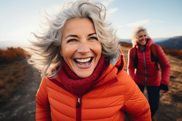 Zdjęcie portret szczęśliwej starszej kobiety śmiejącej się podczas wędrówki w górach
