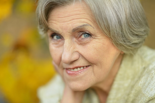 Portret szczęśliwej starszej kobiety w jesiennym parku