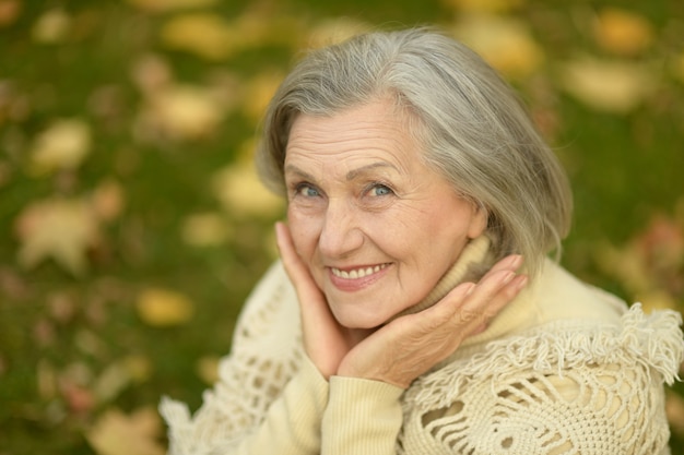 Portret szczęśliwej starszej kobiety w jesiennym parku