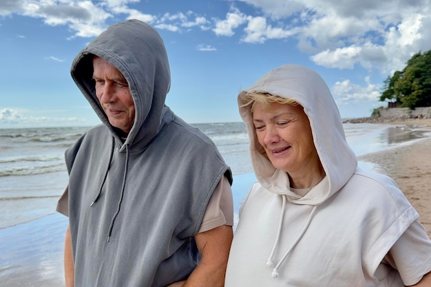 Portret szczęśliwej starszej starszej pary zakochanych spacerów po plaży w letnim uśmiechu śmiechu baw się dobrze