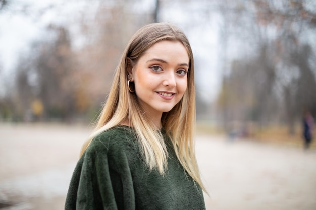 Portret szczęśliwej uśmiechniętej młodej blond kobiety w parku