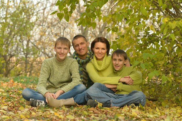 Portret szczęśliwej uśmiechniętej rodziny w jesiennym lesie