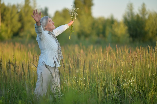 Portret szczęśliwej uśmiechniętej starszej kobiety w polu