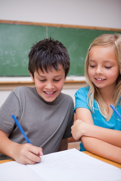 Portret szczęśliwi ucznie pracuje wpólnie