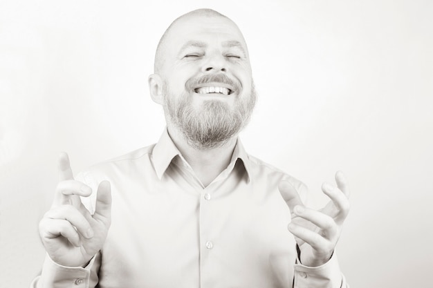 Portret szczęśliwy brodaty mężczyzna w koszuli z podniesionymi rękami. błogość i pozytywne emocje