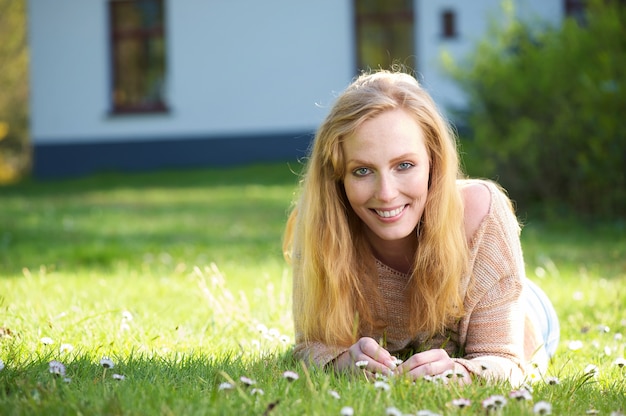 Portret szczęśliwy kobiety lying on the beach na trawie outdoors