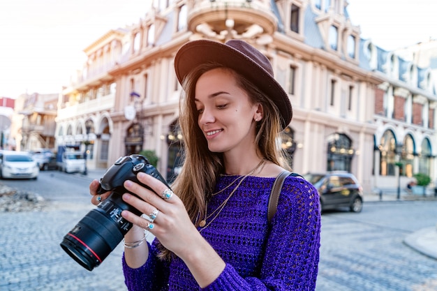 Portret szczęśliwy piękny fotograf z kamerą przy ulicą