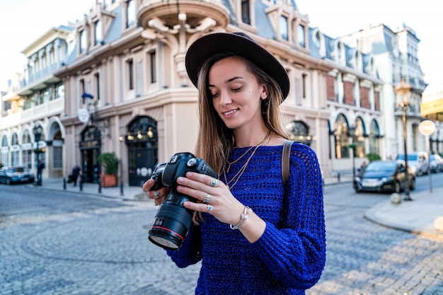 Portret szczęśliwy piękny fotograf z kamerą przy ulicą