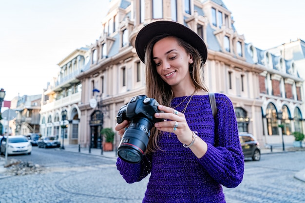 Portret szczęśliwy piękny fotograf z kamerą przy ulicą