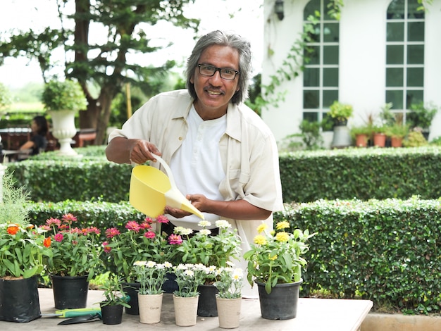 Portret szczęśliwy starszy mężczyzna w kwiatu ogródzie