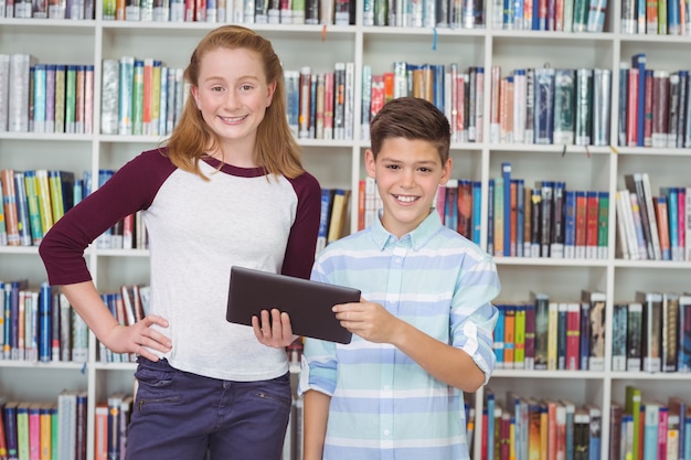 Portret Szczęśliwy Studentów Trzymając Cyfrowy Tablet W Bibliotece