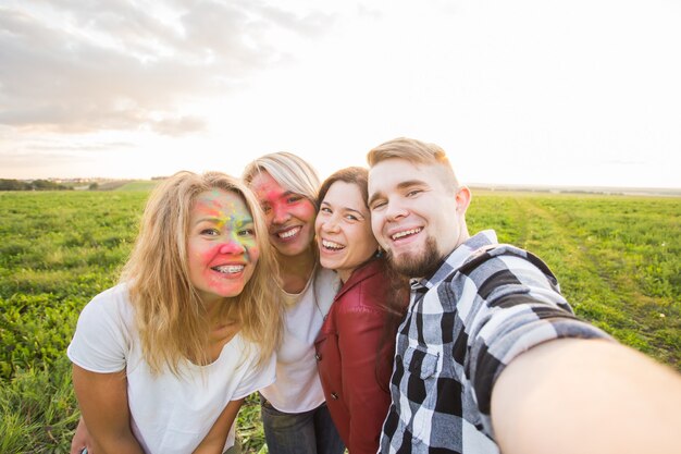Zdjęcie portret szczęśliwych przyjaciół na festiwalu kolorów holi biorąc selfie