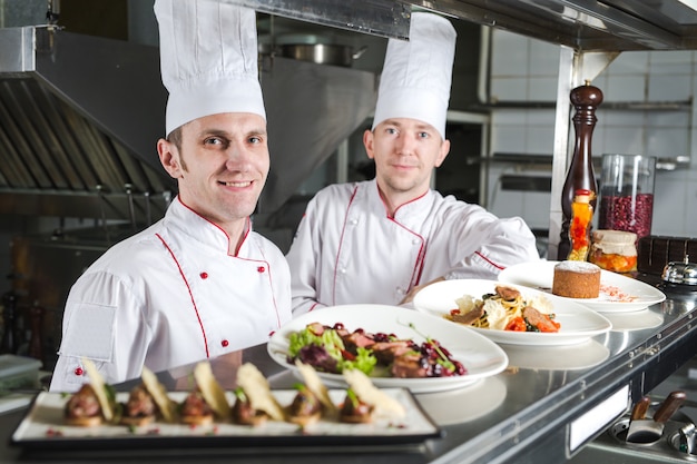 Portret Szefa Kuchni Z Gotowanym Jedzeniem W Kuchni W Restauraci.