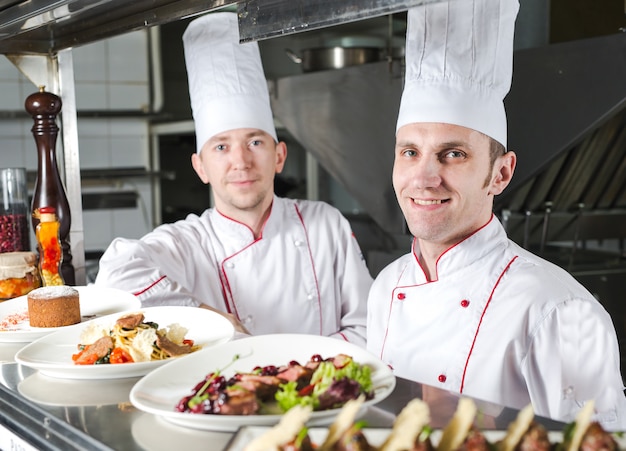 Portret Szefa Kuchni Z Gotowanym Jedzeniem W Kuchni W Restauraci.