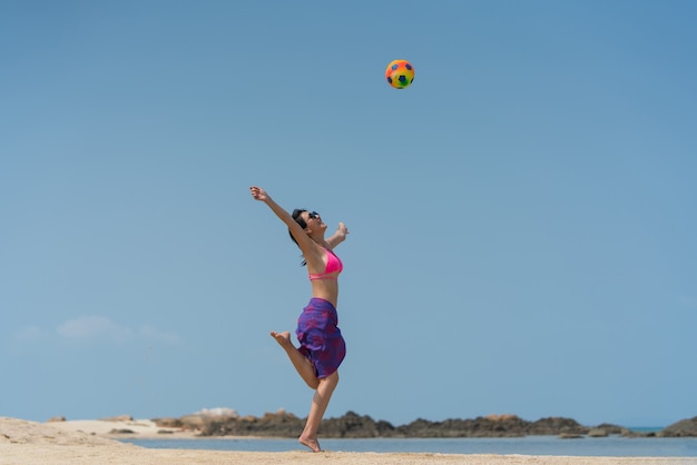 Portret tajskiej kobiety w bikini z piłką pozuje na plaży