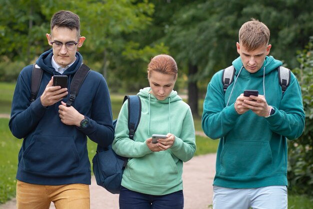 Portret Trzech Studentów Z Plecakami Na Zewnątrz W Parku