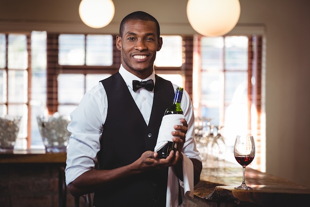 Portret trzyma barman butelkę wina