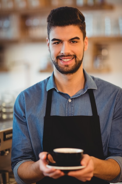 Portret trzyma filiżankę kawy uśmiechnięty mężczyzna