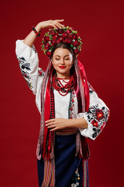 Portret ukraińskiej kobiety w tradycyjnych strojach etnicznych i kwiatowy czerwony wieniec na tle viva magenta studio Ukraińska narodowa haftowana sukienka wywołanie vyshyvanka Módlcie się za Ukrainę