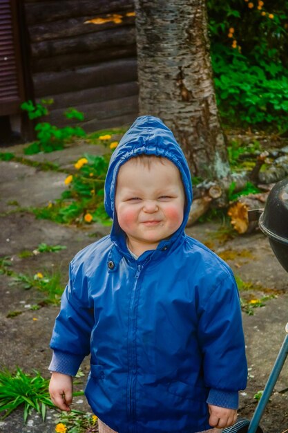 Zdjęcie portret uroczego chłopca stojącego przy roślinach