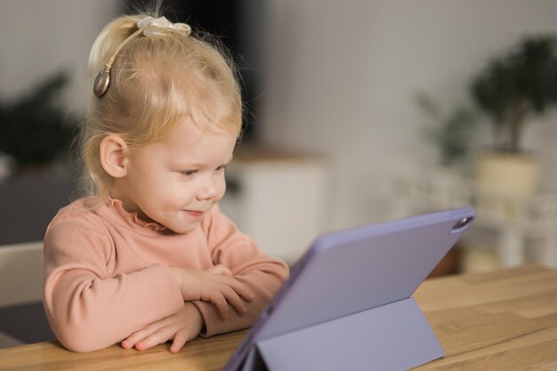 Zdjęcie portret uroczego chłopca używającego laptopa w domu