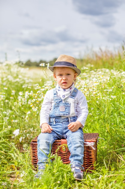 Portret uroczego dziecka z kwiatami w polu rumianku