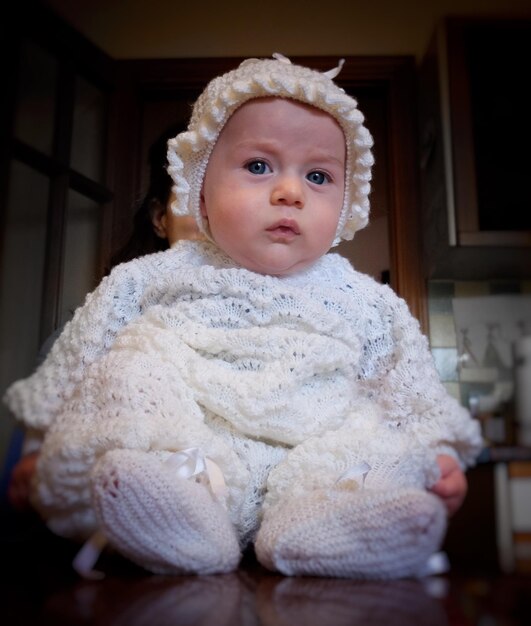 Zdjęcie portret uroczej dziewczynki w białych ciepłych ubraniach w domu