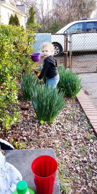Zdjęcie portret uroczej dziewczyny stojącej przy roślinach