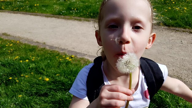 Zdjęcie portret uroczej dziewczyny trzymającej trawę